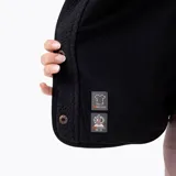 Campera polar sherpa de mujer en color negro, con cuello alto, cierre de botones a presión, bolsillos frontales con refuerzo en nylon y parche con logo de la marca en el pecho.