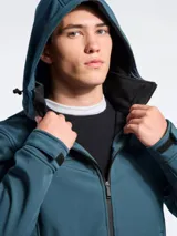 Campera de abrigo tipo softshell color azul marino, con capucha, cierre frontal y bolsillos laterales con cierre. Presenta interior en color negro y ajuste en los puños.