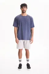 Remera de manga corta raglán con lavado acid wash color azul, de corte holgado, cuello redondo y estampa tipográfica en la espalda.