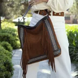Bolso marrón de cuero vacuno con flecos y detalles de tachas. Tiene correa de mano y correa larga extraíble.