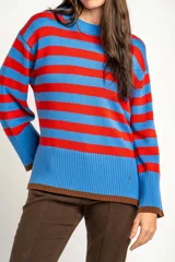 Sweater de punto con diseño de rayas horizontales en azul y rojo, cuello redondo y puños con terminación en color marrón.