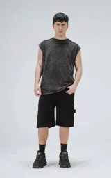 Remera sin mangas (tipo musculosa) de algodón, color negro con efecto gastado (acid wash). Presenta recortes diagonales en el frente y mangas cortas caídas, con cuello redondo.
