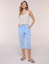 Pantalón capri de algodón color celeste, con cintura elastizada y cordón frontal de ajuste, bolsillos laterales estilo parche y largo por debajo de la rodilla.