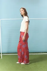 Pantalón de algodón color rojo con estampado de soles en color azul, de corte recto y cintura elástica con cordón ajustable.