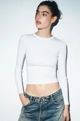 Camiseta de manga larga en color marrón oscuro, confeccionada en tejido de algodón. Presenta un diseño de corte ajustado (slim fit) con cuello redondo.