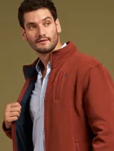 Campera de poliéster color ladrillo con cierre frontal, cuello alto y bolsillos laterales.