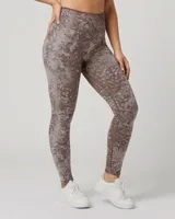 Calza deportiva ajustada, tiro alto, con estampado abstracto en tonos marrón y gris claro.