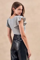 Top color crudo de lurex con corte ajustado, cuello redondo y mangas cortas con volados.