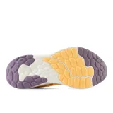 Championes New Balance Fresh Foam Arishi V4, color durazno con logo "N" en lila y suela blanca con detalles en lila.