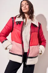 Campera puffer roja y rosa con cuello y puños de piel sintética color crema, cierre frontal con cremallera y detalles de cuero sintético negro.