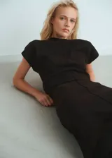 Jersey de punto fino color negro, con cuello redondo, manga corta y diseño entallado.