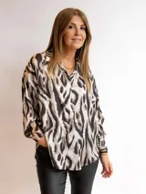 Camisa de satén estampada con diseño animal print en tonos blanco, negro y marrón. De corte holgado y manga larga.