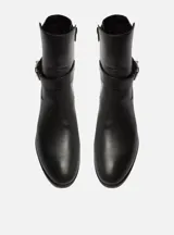 Bota corta negra de cuero con hebilla metálica plateada.