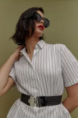 Camisa blanca con rayas verticales azul marino, de corte clásico, cuello camisero y manga corta.