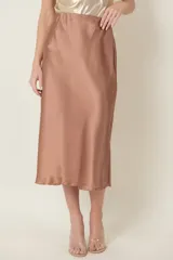 Pollera midi color marrón cobrizo de satén de seda, corte al bies y cintura elastizada.