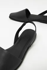 Zapato destalonado de cuero color negro, con punta cuadrada y diseño minimalista.