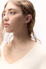 Sweater de tejido de punto color celeste, con escote en V y calce holgado. Confeccionado en lana italiana.