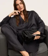 Pantalón wide leg de cintura alta, confeccionado en tejido satinado color negro, con elástico y lazo en la cintura y bolsillos delanteros.