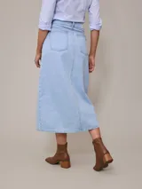 Falda midi de jean azul claro con corte en el centro del frente.