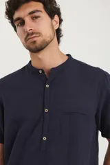 Camisa de manga corta con cuello mao y cierre frontal parcial con botones de coco. Confeccionada en una mezcla de lino y algodón.