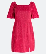 Vestido corto rojo con lunares blancos, escote cuadrado, mangas cortas abullonadas y abertura lateral en la falda.