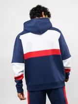 Canguro con capucha de Umbro del Club Nacional de Football, con diseño de bloques de color en azul, blanco y rojo. Presenta bolsillo frontal tipo canguro, cordones ajustables en la capucha y logos bordados del club y la marca.