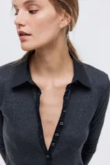 Vestido midi de punto fino color gris oscuro, con cuello camisero, tapeta de botones frontal, manga larga y falda con leve vuelo.