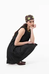 Vestido corto sin mangas de denim negro, con silueta evasé, calce suelto y costuras pespunteadas a contratono.