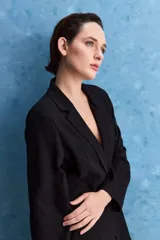 Blazer negro de corte relajado, con solapa clásica y cierre frontal.