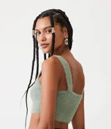 Blusa cropped sin mangas en punto canalé con pelo, escote cuadrado y tirantes anchos.