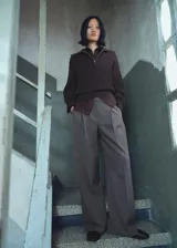 Pantalón de vestir tiro medio con diseño wide leg, pinzas en la parte delantera, bolsillos laterales y cierre con botón, gancho y cremallera.