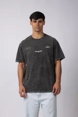 Remera de algodón con efecto lavado gastado, cuello redondo y mangas cortas. Presenta estampados minimalistas en el frente con el logo de la marca y la frase 'Local Based, Global Attitude'.