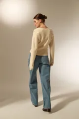 Saco de punto con cuello en V y cierre frontal con botones. Presenta un diseño ajustado al cuerpo, manga larga y terminación acanalada en el ruedo.