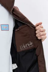 Cazadora acolchada de color azul marino con diseño de costuras onduladas, cierre frontal con cremallera y cuello alto. Presenta bolsillos frontales y un ajuste cómodo.