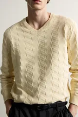 Jersey de punto regular fit color beige, con cuello redondo y diseño de textura geométrica en zigzag.