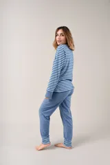 Pijama largo celeste con estampado de ondas horizontales en azul y blanco. Camiseta de manga larga con cuello en V abotonado y pantalón con puños.