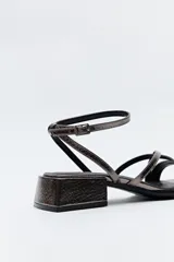 Sandalias de vestir color peltre con tiras finas, taco medio cuadrado y pulsera al tobillo con hebilla.
