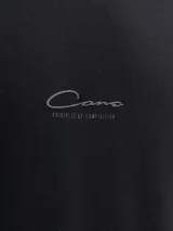 Remera negra de manga corta con cuello redondo y calce relajado, confeccionada en tejido de punto interlock con sutil estampado frontal.