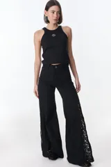 Pantalón de jean negro de pierna ancha, con inserciones de encaje lateral que aportan amplitud y diseño.