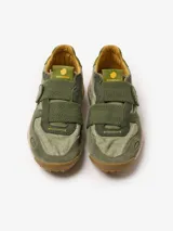 Zapatillas Satorisan modelo Chacrona Lin.Ela., color verde militar con detalles en mostaza y suela speckle con tacos de goma verde. Presentan cierre de velcro con aplique en forma de corazón y diseño de estilo técnico.