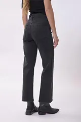 Pantalón de jean negro de corte recto con sutiles detalles de brillo en toda la prenda. Presenta tiro alto, cierre frontal con botón y bolsillos laterales y traseros.