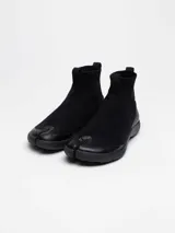 Bota negra tipo pezuña marca Tabi, con capellada de tejido Tencel y suela de caña de azúcar.