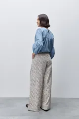 Pantalón de tiro alto con silueta amplia y piernas rectas, confeccionado en algodón con estampado floral. Cuenta con cierre frontal de botón y cremallera, y bolsillos laterales funcionales.