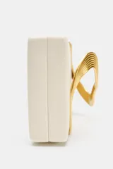 Cartera tipo clutch de color beige con solapa, cierre imantado y detalle metálico dorado con diseño curvo en el frente. Cuenta con bolsillo interior y correa de cadena metálica opcional.