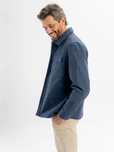 Tapado de paño en color azul, con diseño de sobrecamisa, cierre frontal con botones, cuello clásico y bolsillos frontales con solapa.