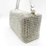 Bolso rectangular verde cubierto de strass, con asa corta de cuero sintético y asa larga de cadena desmontable.