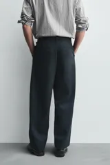 Pantalón de corte balloon fit confeccionado en una mezcla de lyocell y algodón. Presenta cierre frontal con cremallera y botón, bolsillos laterales y bolsillos traseros de vivo.
