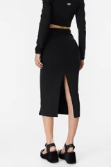 Falda midi negra de corte ajustado, con detalle drapeado y abertura lateral.