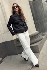 Pantalón de jean wide leg en color blanco, de tiro alto y corte ancho con dobladillo ancho en los bajos.
