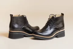 Botines negros de cuero con cordones, caña baja y taco cuadrado.